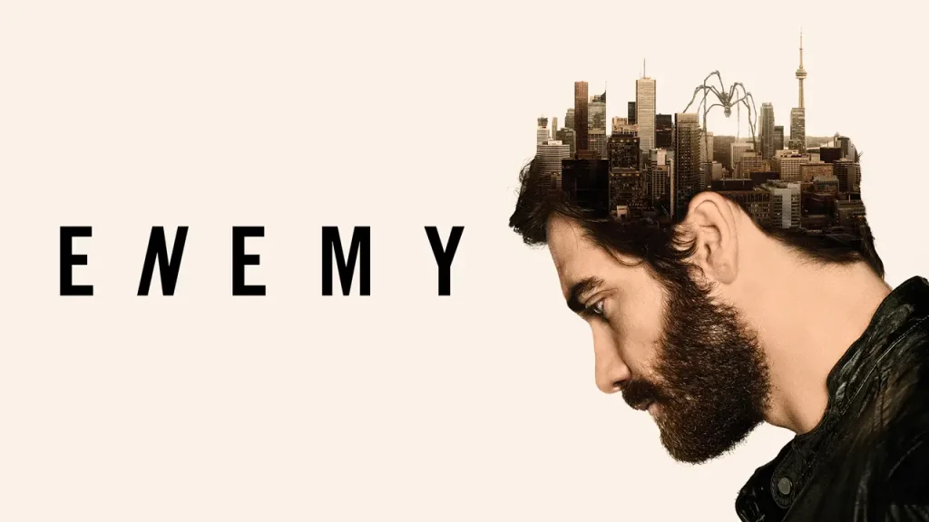 Surreal psychological thriller poster for Enemy (2013), featuring a bearded man looking downward with a Toronto city skyline and giant spider emerging from his head.